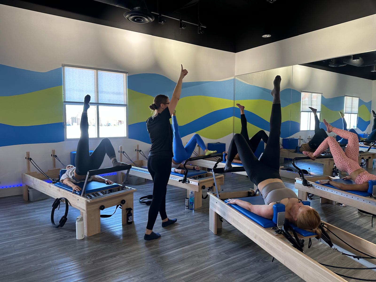 Client practicing on reformer machine at a Pilates Reformer Studio Las Vegas to enhance core strength and flexibility.
