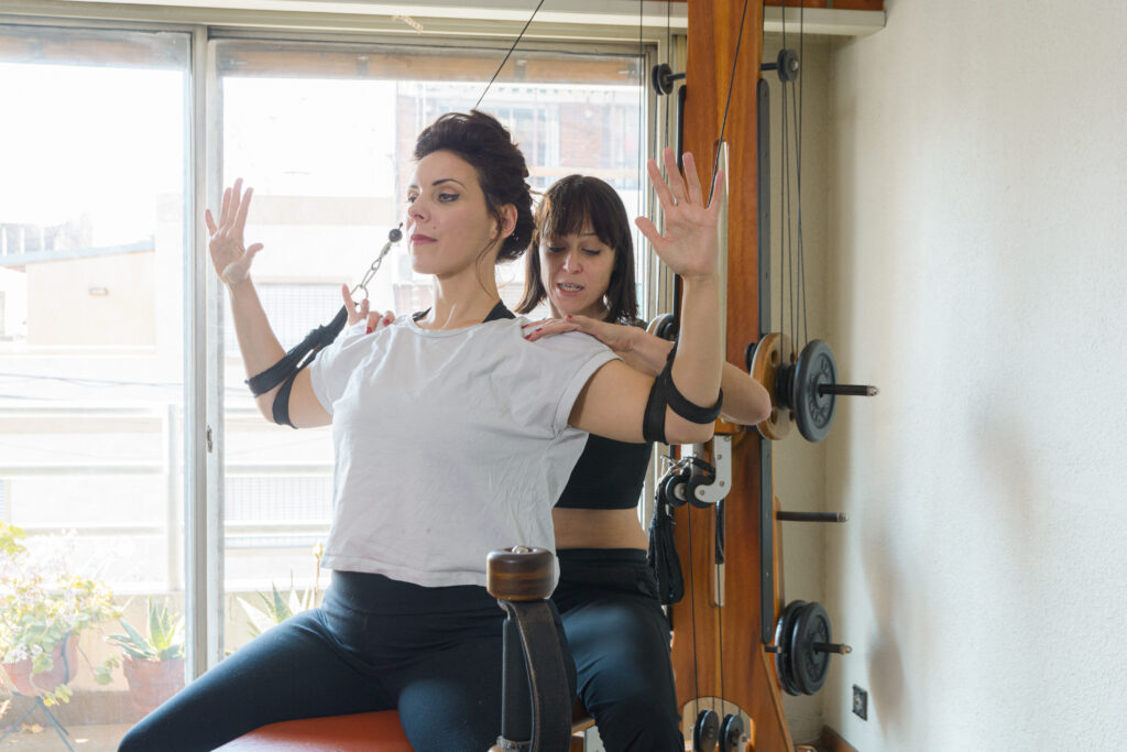 The best pilates instructors guiding a client through a reformer workout for faster results.